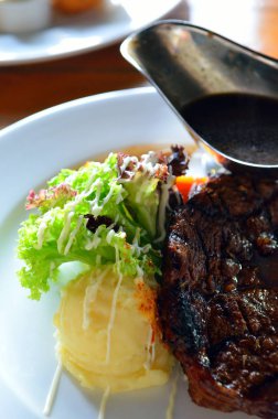 Kızarmış biftek et suyu sosu ile