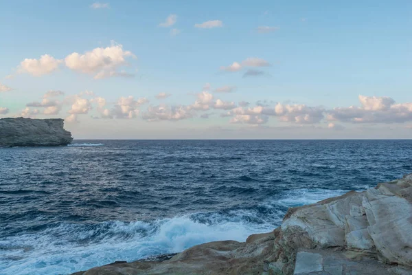 Gün Batımında Mavi Gökyüzü ve Beyaz Bulutlar ile Güzel Deniz. Yunanistan, Avrupa. Dağlardan uzaktaki denize bak. Gün batımındaki dalgalar. Okyanus, görmek, dalgalar, gün batımı, gündoğumu, seyahat, tatil, aşk, gökyüzü, bulutlar, su.
