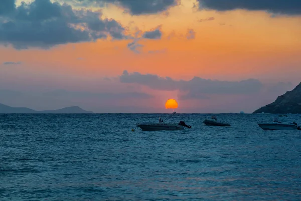 Boats on a colorful sunset. Morning sunrise on the sea and boats in background.