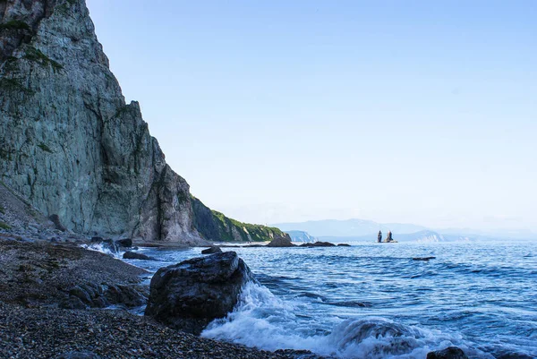 La costa rocosa del mar está sujeta por rocas colgantes. Ola. — Foto de Stock