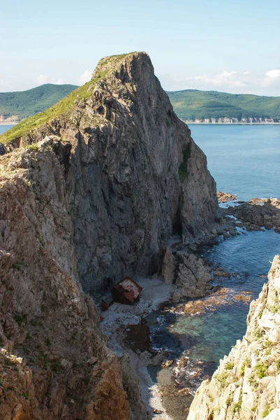 Un vieux navire naufragé se tient sur le rivage au pied d'un roc — Photo