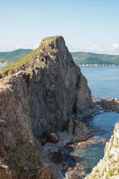 Un vieux navire naufragé se tient sur le rivage au pied d'un roc — Photo