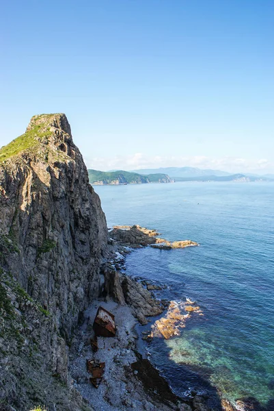 Un vieux navire naufragé se tient sur le rivage au pied d'un roc — Photo