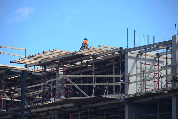 İnşaat işçisi metal kirişler inşa ediyor.