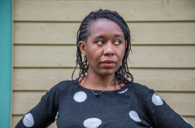 Polka bluzunun içine bakan kendinden emin Afrikalı Amerikalı öğrenci. Eğitim, çeşitlilik, kampüs hayatı ve akademik güçlendirme kampanyaları için ilham verici portreler.