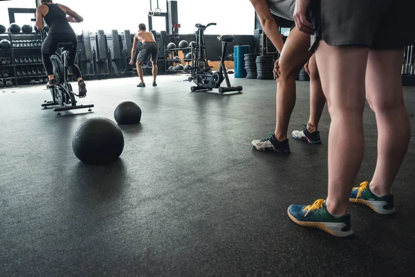 Athletic people working out in an open gym environment.