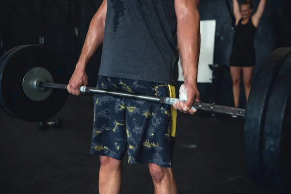 Athletic people working out in an open gym environment.