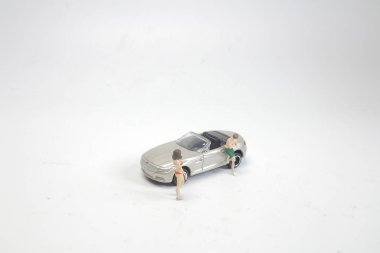 mini figür bikini kız arabanın yakınında poz