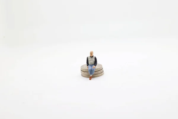 Figur Sitzt Auf Einem Stapel Münzen Geldkonzepte — Stockfoto