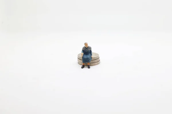 Figur Sitzt Auf Einem Stapel Münzen Geldkonzepte — Stockfoto