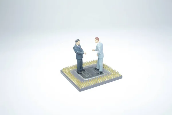 mini figure business handshake on computer chip