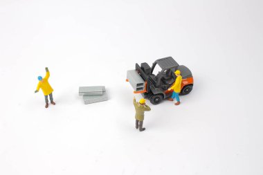 seçici odak minyatür işçinin forklift makine, üzerinde beyaz izole sürüş.
