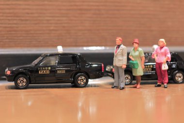  küçük bir insan figürü ve bir taksi