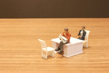 Mini insanlar oturup gazeteyi okuyor