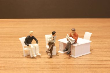 Mini insanlar oturup gazeteyi okuyor