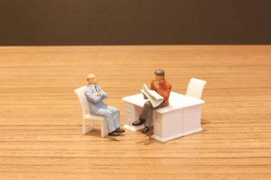 Mini insanlar oturup gazeteyi okuyor