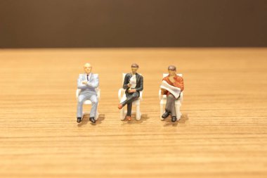 Mini insanlar oturup gazeteyi okuyor