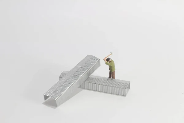 Der Mini-Figurenmann schneidet das Eisen an Bord — Stockfoto