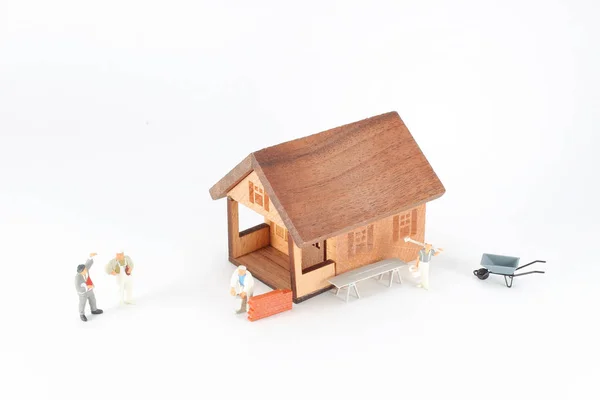 Uma casa de construção com mini figura trabalhador — Fotografia de Stock