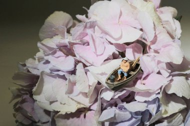 Mini figür çiçekte balık tutuyor.