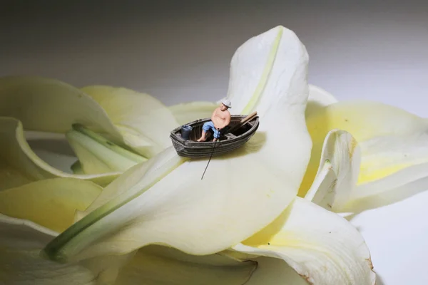 De minifiguur is vissen op de bloem — Stockfoto