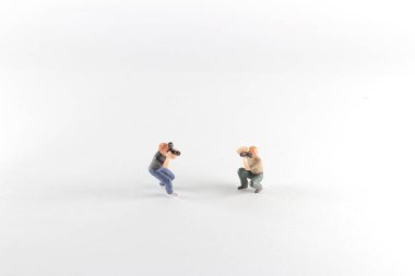 Arka planda duran küçük bir fotoğrafçı.