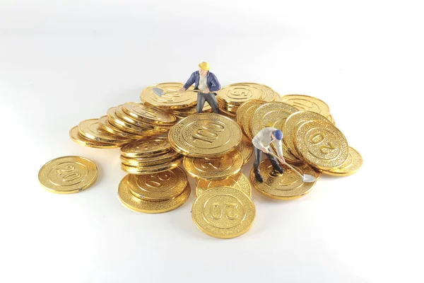 Uma figura de trabalhador que se move das moedas de ouro  ,. — Fotografia de Stock