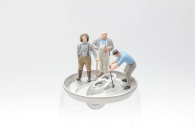 İşçi adam konserve açıyor. Mini işçiler sodanın üstünde 