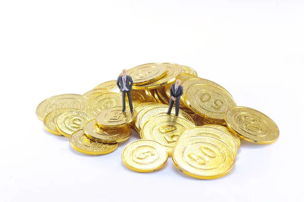 Μια επιχειρηματική φιγούρα στέκεται πάνω στα χρυσά νομίσματα. — Φωτογραφία Αρχείου