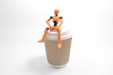 Beyaz bir kahve fincanında oturan figürler.