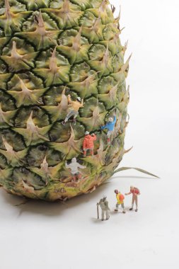 Bir grup minyatür figür pipeti üzerinde yürüyor.