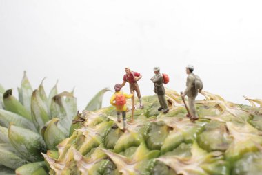 Bir grup minyatür figür pipeti üzerinde yürüyor.