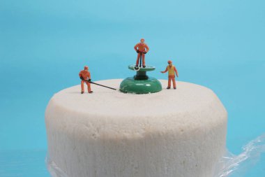 Mini bir figür taze yeşil hindistan cevizi meyvesini açıyor.