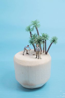 Mini figür taze yeşil hindistan cevizi meyvesini açıyor.