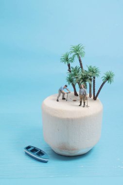 Mini figür taze yeşil hindistan cevizi meyvesini açıyor.