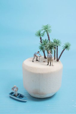 Mini figür taze yeşil hindistan cevizi meyvesini açıyor.