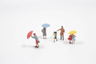 Mini figür şemsiyeyle yağmurda yürür.,
