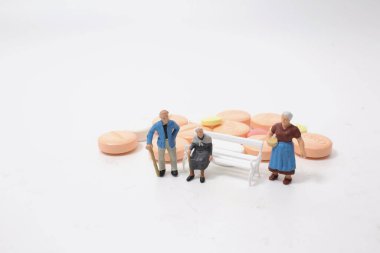 Beyaz hapların üzerinde oturan yaşlı bir şahıs..