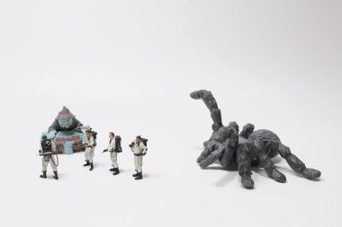 Canavarın karşısında figürlerden oluşan bir takım.