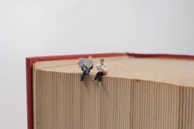 Arka plan eğitimi ya da iş konsepti olarak kitap üzerinde oturan insanlar