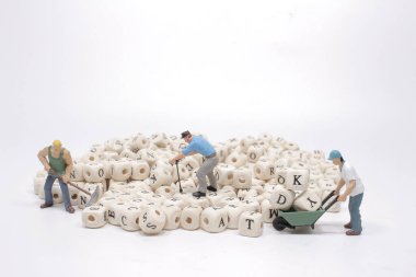 Bir işçi figürü ahşap küpü kaldırır. 