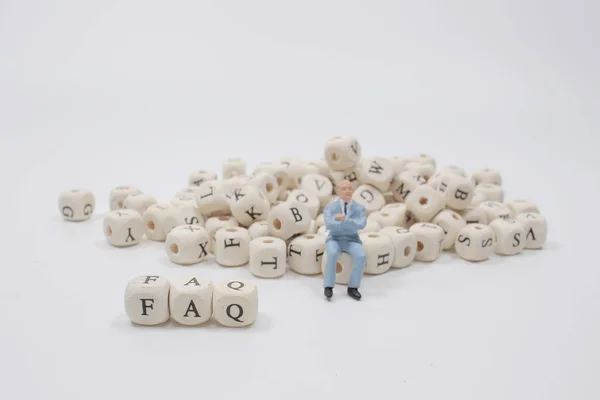 a Small plastic figure with  the FAQ blocks