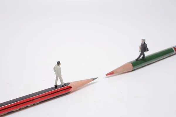 the mini  people walking on a pencil with meeting