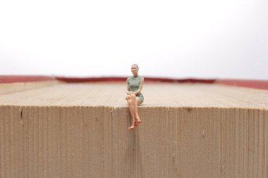 Mini insanlar kitap, eğitim veya iş konseptiyle okuyorlar.