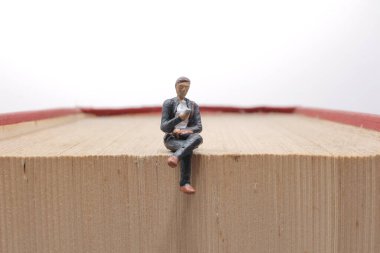 Mini insanlar kitap, eğitim veya iş konseptiyle okuyorlar.