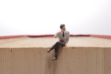 Mini insanlar kitap, eğitim veya iş konseptiyle okuyorlar.