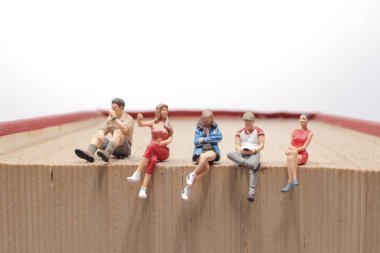 Mini insanlar kitap, eğitim veya iş konseptiyle okuyorlar.