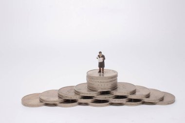 Mini model figürleri madeni para yığınları üzerinde karar veriyor