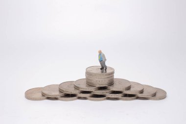 Mini model figürleri madeni para yığınları üzerinde karar veriyor