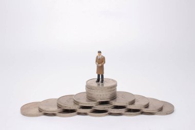 Mini model figürleri madeni para yığınları üzerinde karar veriyor